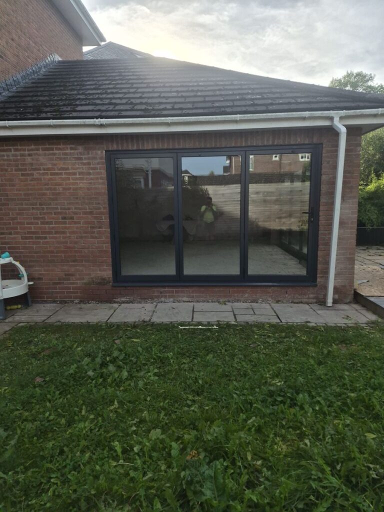 Brick house extension with large sliding glass doors