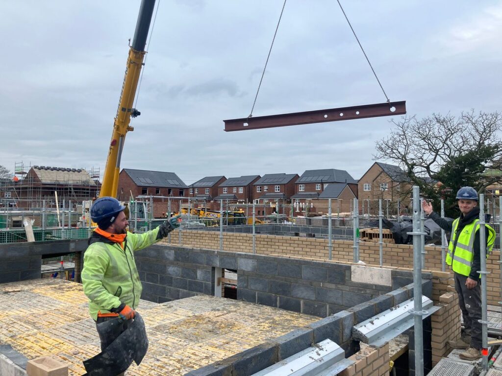 Crane lifting an RSJ steel beam into position